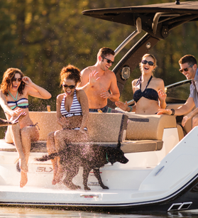Group of people laughing on a Sea Ray boat with a dog