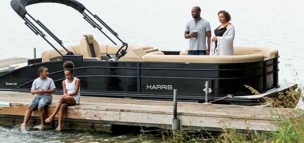 Family on a Harris pontoon boat at a dock