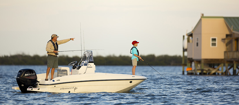 A man and boy fishing on a Bayliner boat