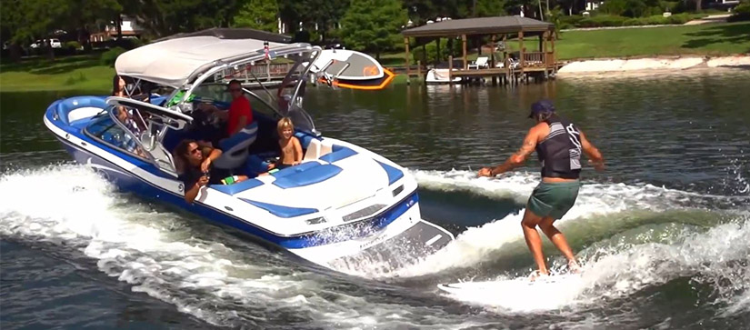 man surfing behind boat