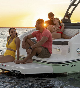 Three people on the swim deck of a Bayliner boat