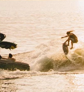 Person wake surfing being towed by a Mastercraft boat