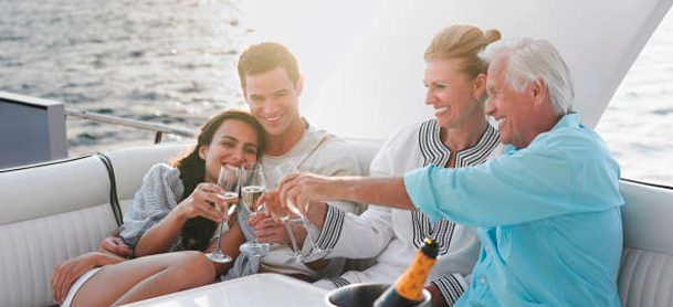 Two couples clinking glasses on a boat