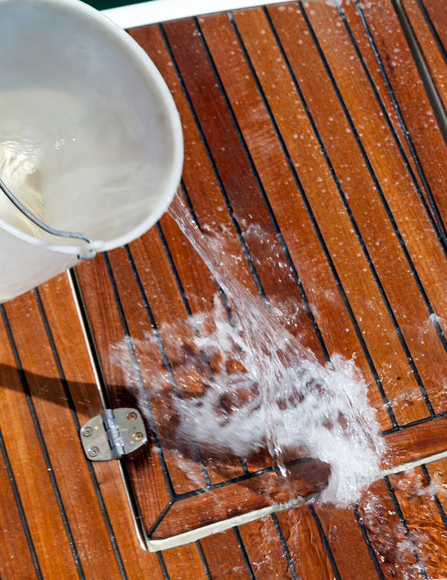 Bucket of water getting poured on a boat deck